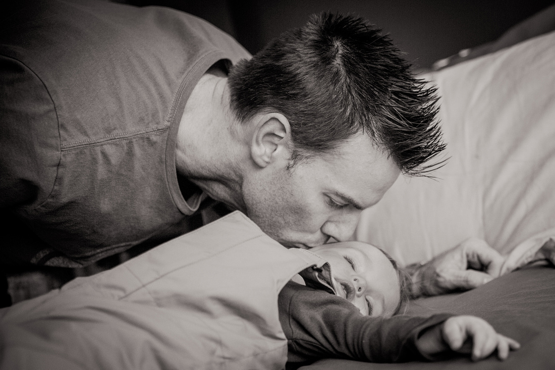 Daddy kissing sleeping daughter