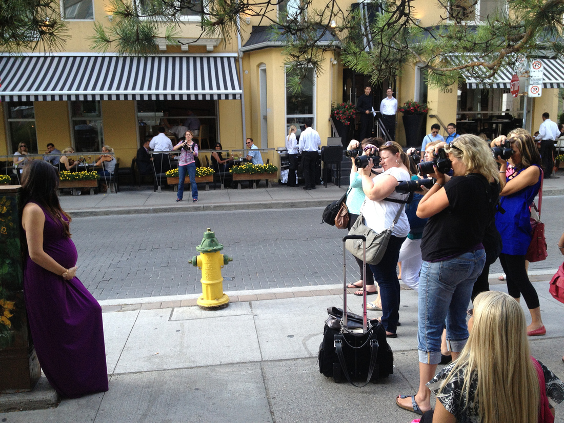 Photographers taken photo of maternity model in Yorkville in front of Sassafraz