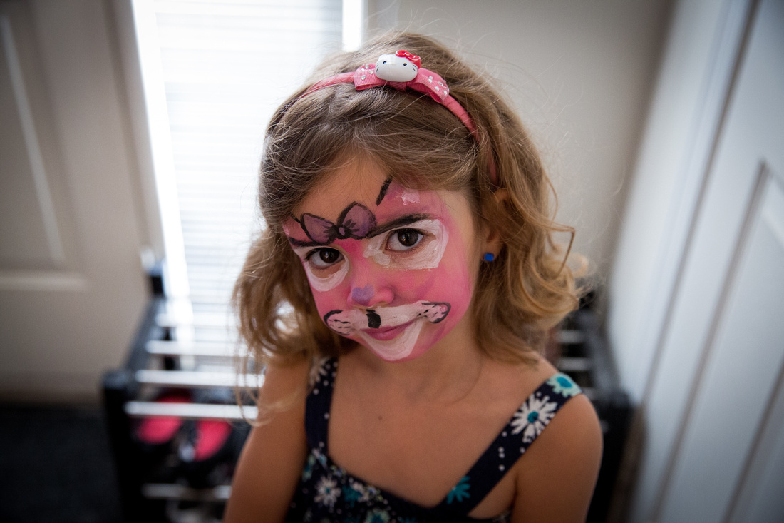 Girl wearing pink cat face paint