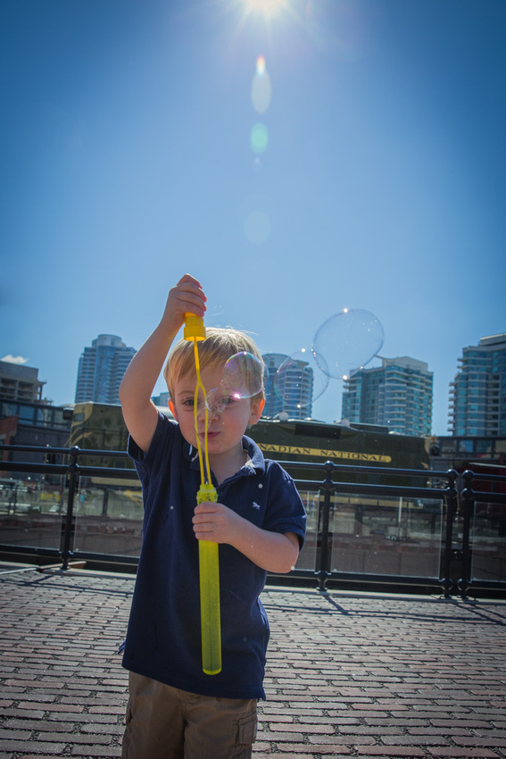 Boy blowing bubbles against the backdrop of the Toronto skyline