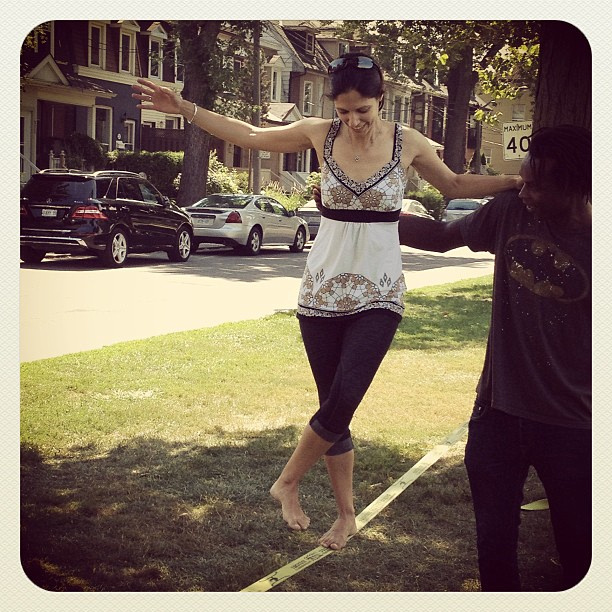 Woman walking on slackline with assistance